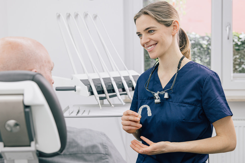 Dr. Elisabeth Ernst zeigt einer Patientin eine individuell angefertigte Knirschschiene